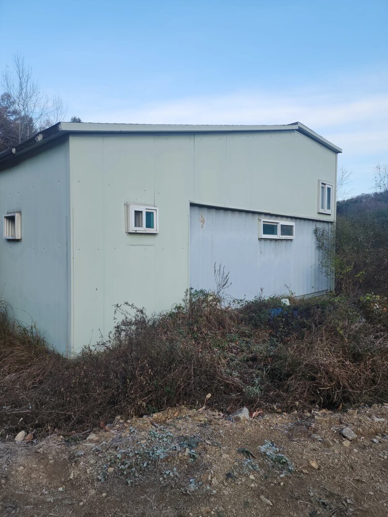 용인판넬창고철거 현장 - 흰색 판넬 외벽으로 마감된 2층형 단독 건물의 측면