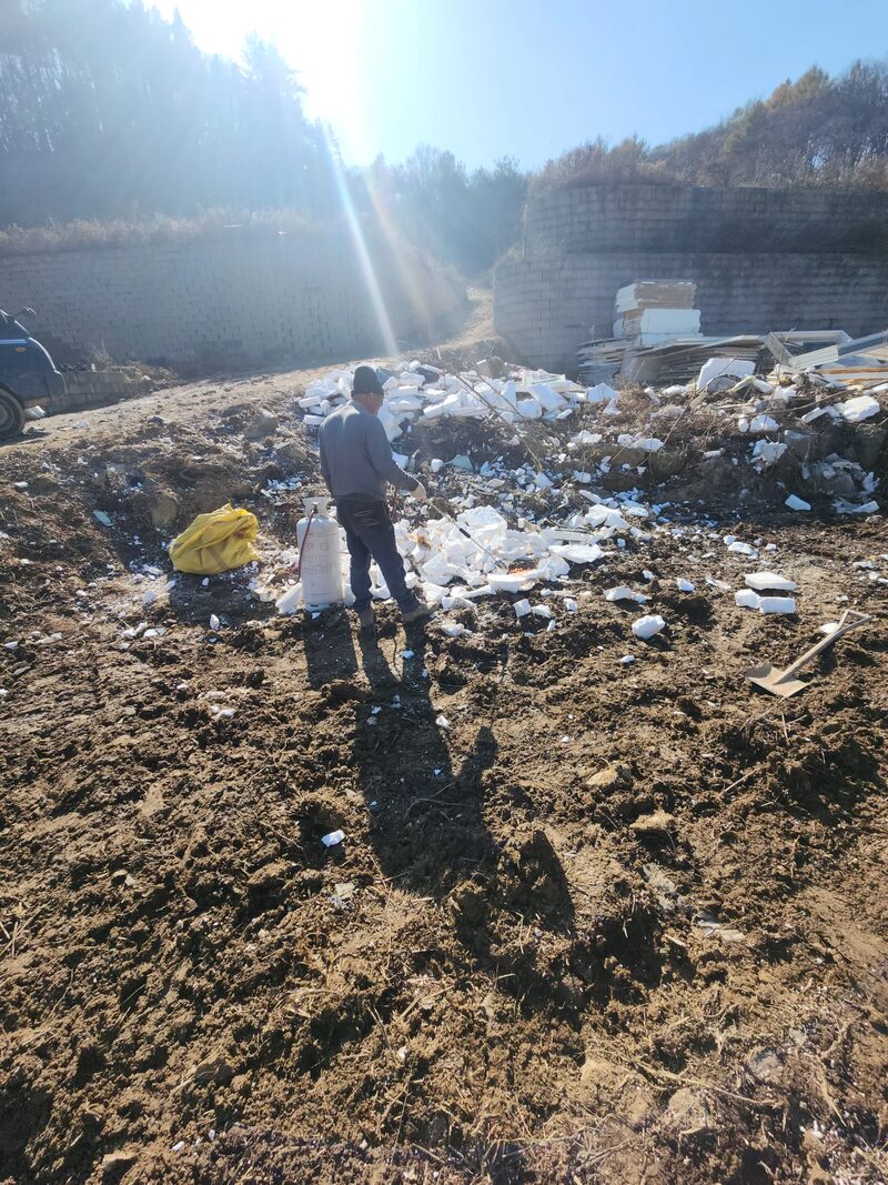 그라스울판넬창고철거 현장 - 철거 잔재가 흩어져 있는 부지에서 작업자가 서서 상태를 확인하는 모습